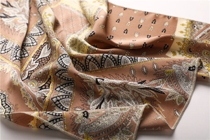 Detailed macro view of paisley pattern satin neckerchief with silky texture and khaki tones