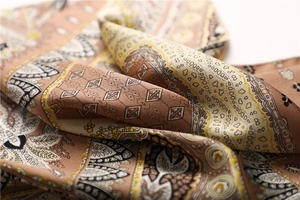 Detailed close-up of paisley pattern satin square scarf with elegant silk-like texture