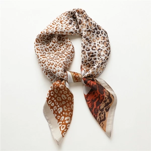 Fashionable leopard print silk scarf with warm orange tones and elegant knotted drape style