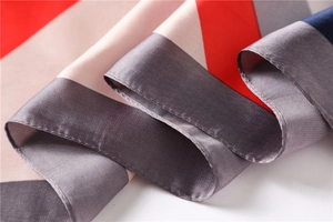 Close-up of geometric color block silk scarf with red, pink, and blue satin texture