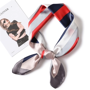 Detail of red and navy geometric striped silk scarf with premium glossy texture