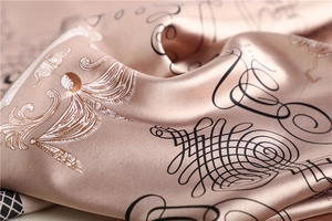 Macro detail of champagne silk scarf with baroque scroll patterns and glossy finish