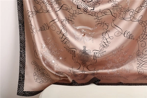Detail of satin silk scarf with rose gold sheen and baroque patterns for women