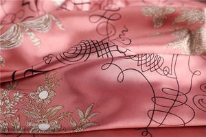 Macro detail of elegant pink satin scarf featuring intricate floral prints and silk texture