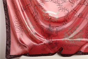 Close-up of pink satin scarf with vintage floral patterns and smooth silk texture