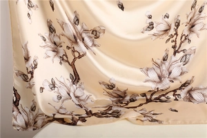 Detailed close-up of champagne satin silk scarf showing elegant magnolia flower patterns