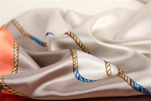 Detail of silk scarf showing satin texture with nautical rope patterns and elegant folds