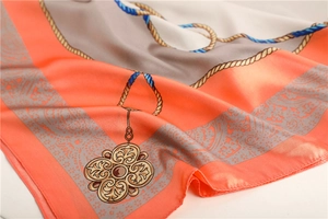 Detailed close-up of retro nautical pattern silk scarf with orange borders and gold coins
