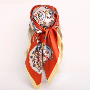 Detail of 90x90cm orange floral silk scarf tied as a headscarf on a model