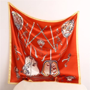 Detailed close-up of red silk scarf with traditional Chinese fans and floral patterns