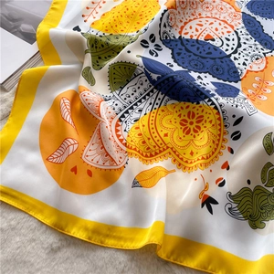 Close-up of silk scarf with colorful folk patterns and yellow edges on soft fur background