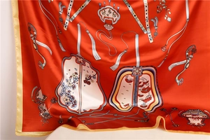 Close-up of orange silk scarf with traditional Chinese patterns and floral details