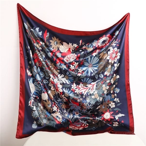 Detail showing the floral print and satin texture of the navy blue square silk scarf