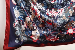 Close-up of floral satin silk scarf with sunflower prints and burgundy borders