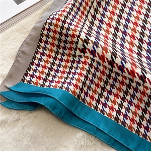 Detailed macro view of silky colorful houndstooth scarf with elegant blue and grey borders