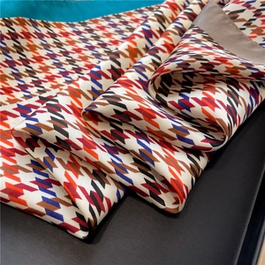 Macro shot of houndstooth silk scarf with premium satin texture and rolled hem edges