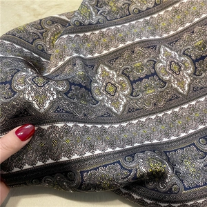 Detail of vintage paisley print silk scarf showing soft fabric texture and navy blue pattern