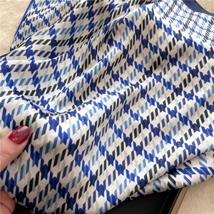 Macro shot of stylish houndstooth silk scarf with smooth texture and geometric pattern