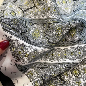 Close-up of black and white paisley pattern silk scarf with yellow floral accents