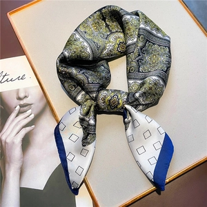 Vintage paisley silk square scarf with blue and gold patterns on a display tray
