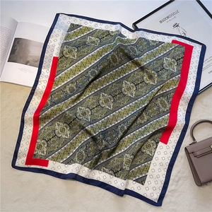 Detail of vintage paisley silk scarf with intricate floral patterns and navy blue border