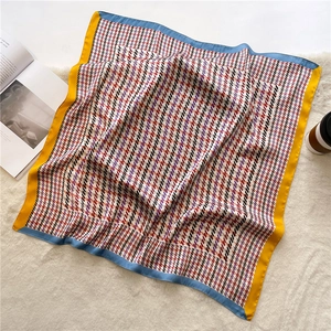 Macro detail of houndstooth silk scarf with purple pattern and bright yellow border