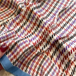 Macro detail of houndstooth silk scarf with purple and orange geometric patterns