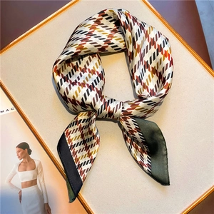 Detailed view of houndstooth silk scarf with contrasting edges and retro geometric patterns