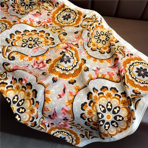 Detailed view of bohemian floral print scarf draped on a leather background