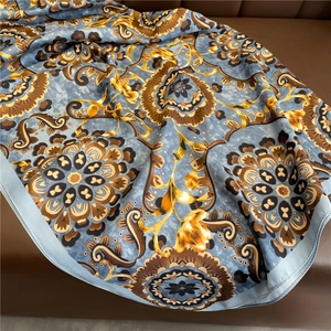 Detail of vintage blue silk scarf with baroque floral patterns and satin texture