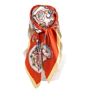 Retro orange printed 90x90cm satin silk scarf styled as a shawl on a model