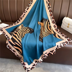 Detail of blue zebra print silk scarf with leopard border on a leather sofa
