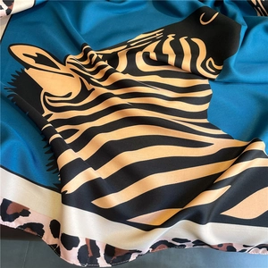 Detailed texture of blue silk scarf featuring zebra print and leopard pattern borders