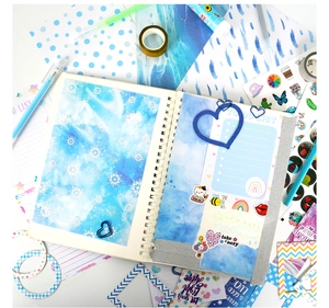 Detailed flat lay of blue DIY journal set including cute stickers and decorative tapes
