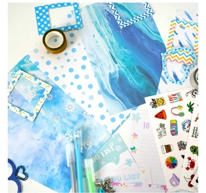 Detailed flat lay of blue DIY journal set including stickers, tape, and decorative papers