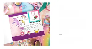 Detail of glitter cartoon stickers featuring unicorns and rainbows on a pink journal