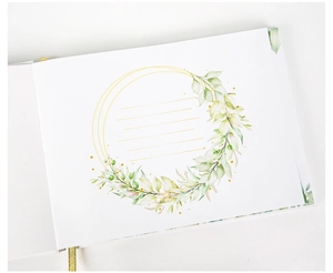 Detail of wedding guest book pages with watercolor leaf wreaths and gold lines