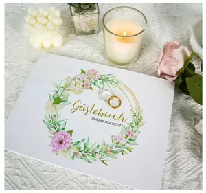 Detail of white matte wedding guest book with floral wreath and gold foil German text