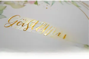 Macro detail of gold foil lettering on a white floral wedding guest book cover