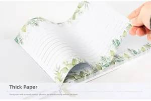 Close-up of thick paper inner pages with green eucalyptus leaf border and smooth texture