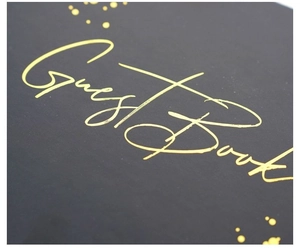 Close-up of elegant gold foil stamped Guest Book text on textured black matte cover