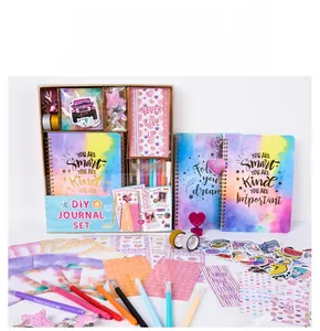 Detail showing DIY journal set with spiral notebook, stickers, pens, and decorative tapes