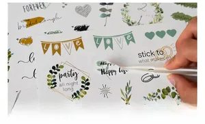 Detail of tweezers picking a Happy Life sticker from the wedding scrapbook set