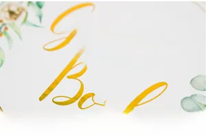 Close-up of gold foil stamped Guest Book text with floral design on white cover