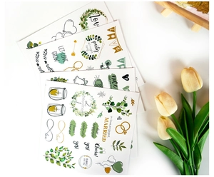 Close-up of elegant wedding guest book stickers with gold foil floral and romantic motifs