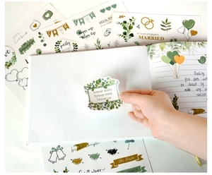 Detail of elegant wedding guest book stickers featuring greenery and gold leaf floral designs