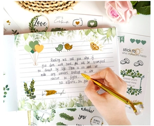 Close-up of botanical wedding guest book kit with gold foil stickers and diamond pen