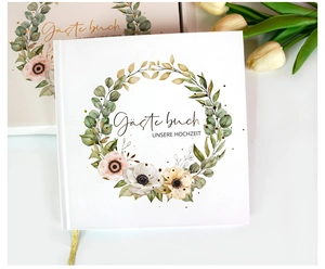 Détail du livre d'or de mariage blanc avec couronne de fleurs et ruban de soie doré
