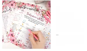 Close-up of floral baby shower game cards with pink pencils and guest writing details