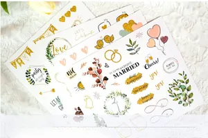 Close-up of elegant wedding guest book stickers with gold foil, hearts and floral motifs